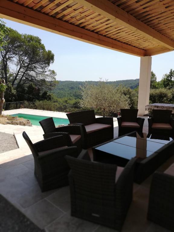 une terrasse avec des chaises, une table et une piscine dans l'établissement villa 12 personnes a lorgues, à Lorgues