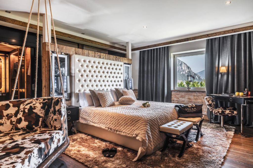 una camera da letto con un letto e una grande finestra di SOLEA DOLOMITI Boutique Hotel a Fai della Paganella