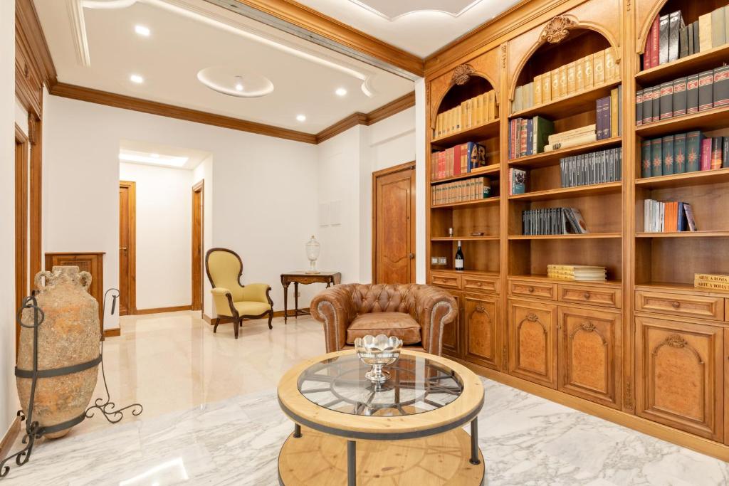 a living room with a table and bookshelves at First Class Rome Apartments in Rome