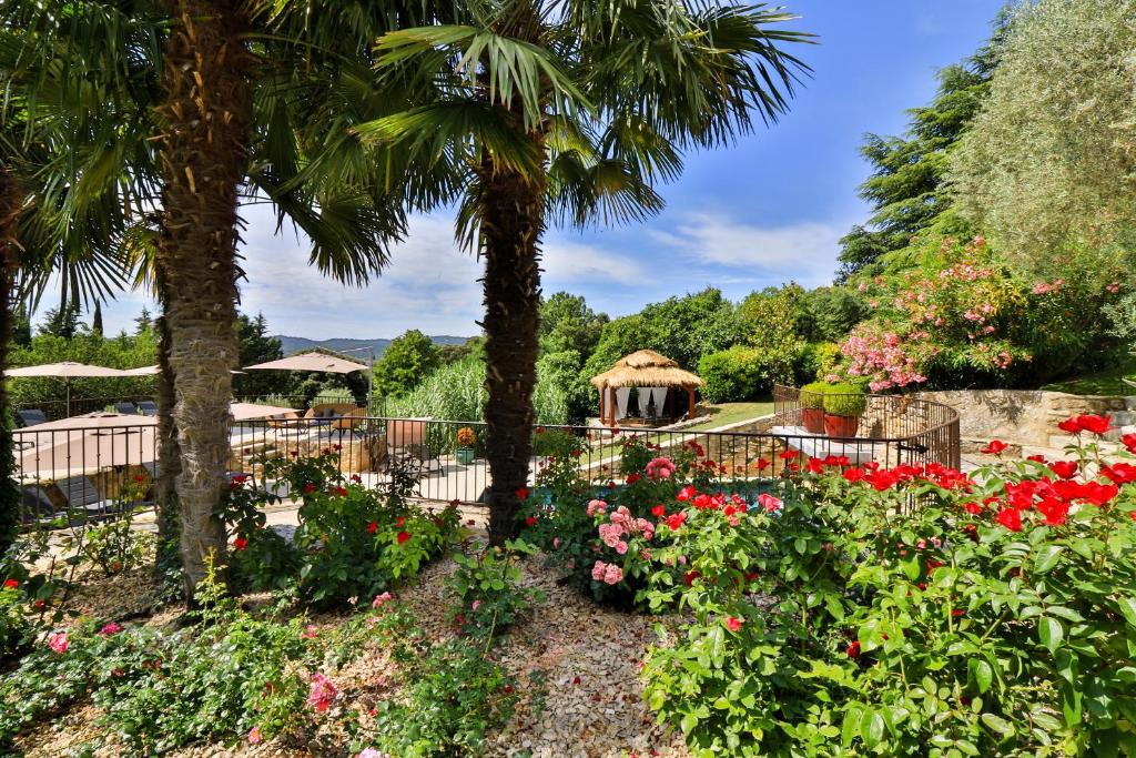 a garden with flowers and a gazebo at Le Mas de la Lombarde in Lourmarin