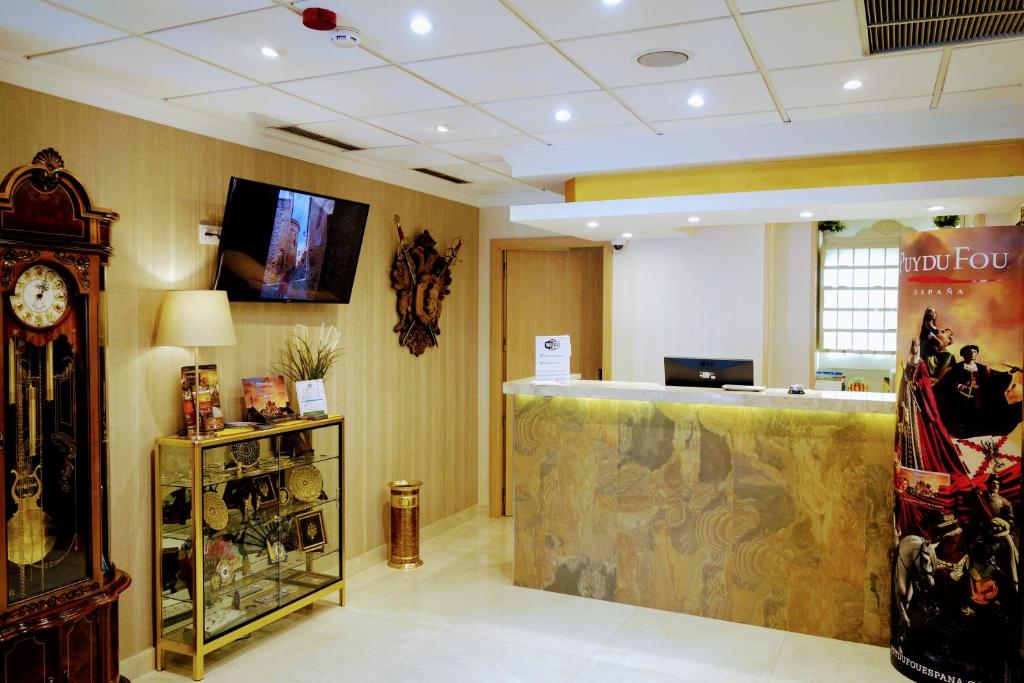 a hotel lobby with a counter and a clock at Hostal Toledo in Toledo