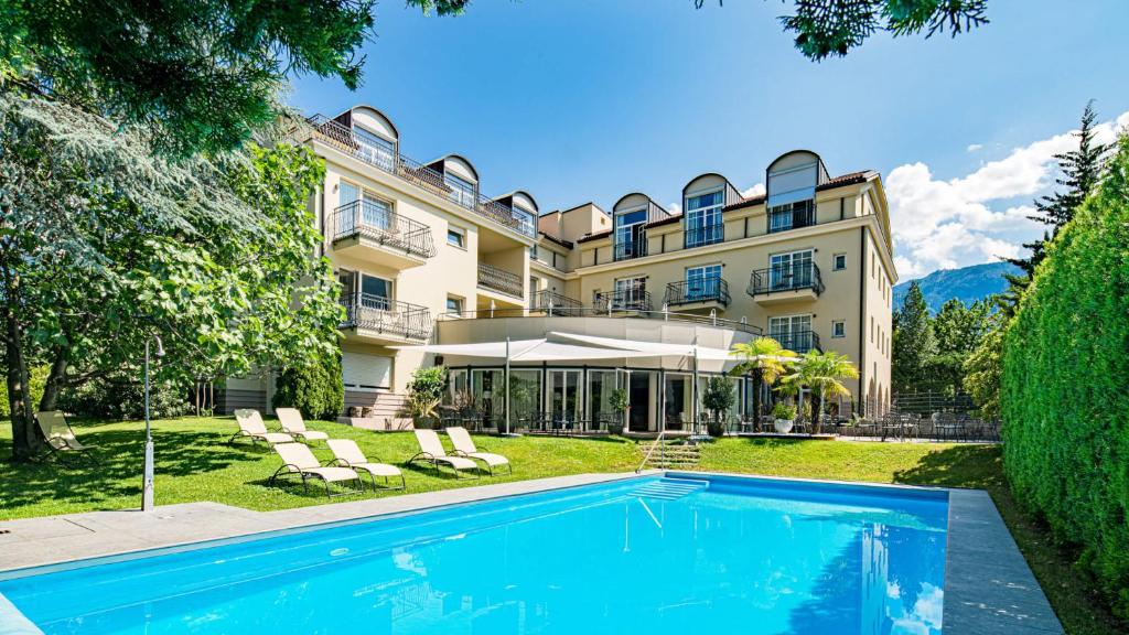 una vista exterior de una mansión con piscina en Hotel Villa Laurus en Merano