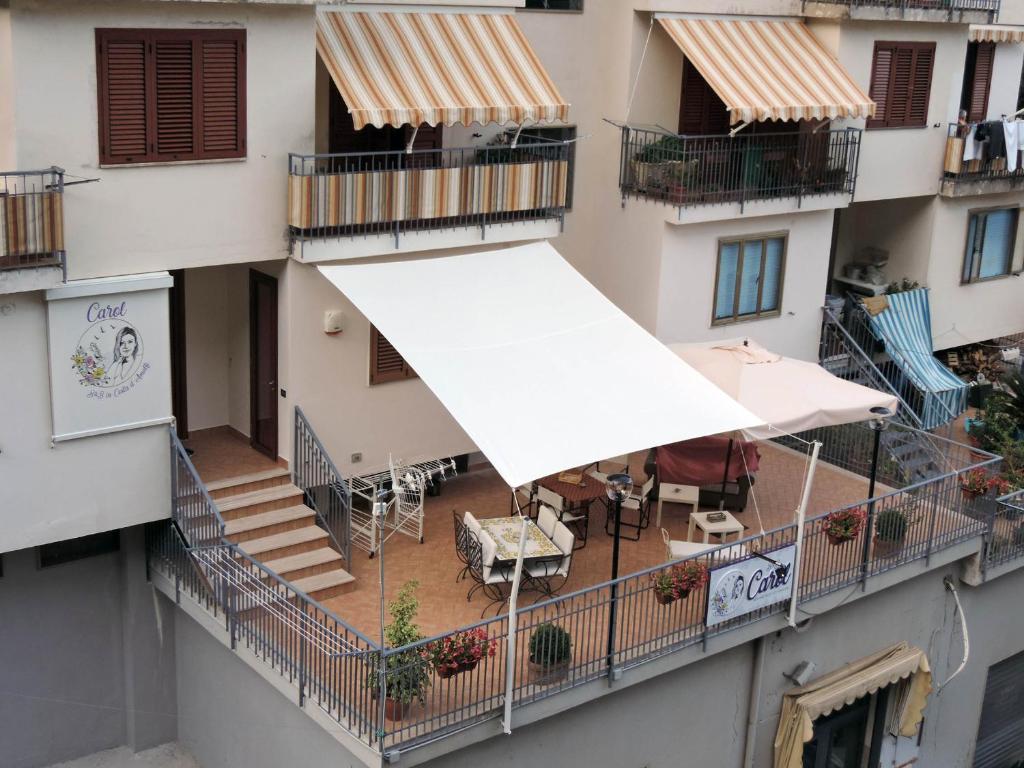 an apartment balcony with a white awning and tables and chairs at B&B Carol in Cetara
