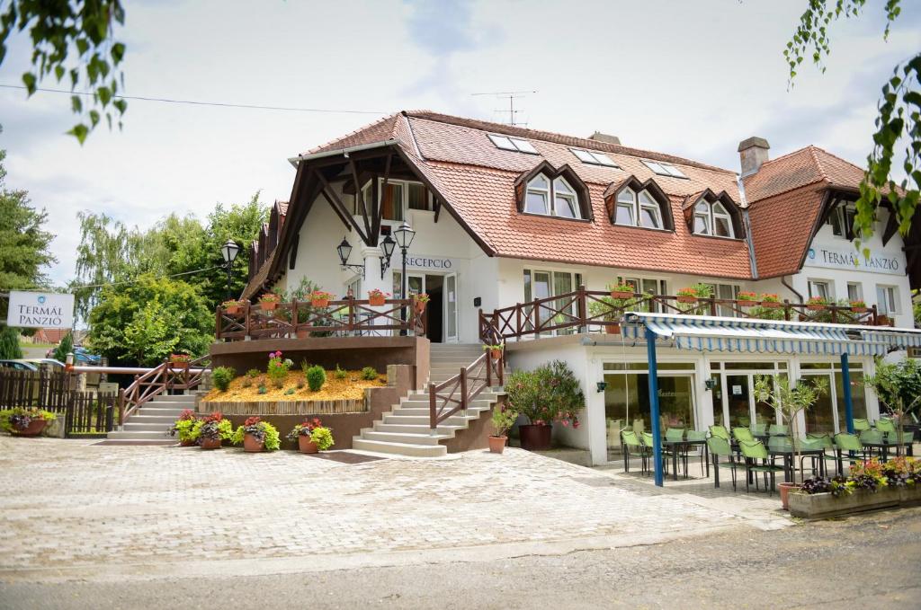 um edifício com escadas e flores em frente em Thermal Panzió Igal em Igal