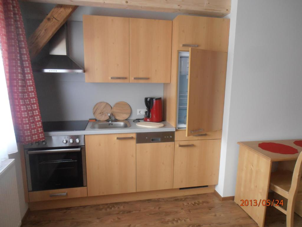 a kitchen with wooden cabinets and a stove at Huberbauer in Johnsbach
