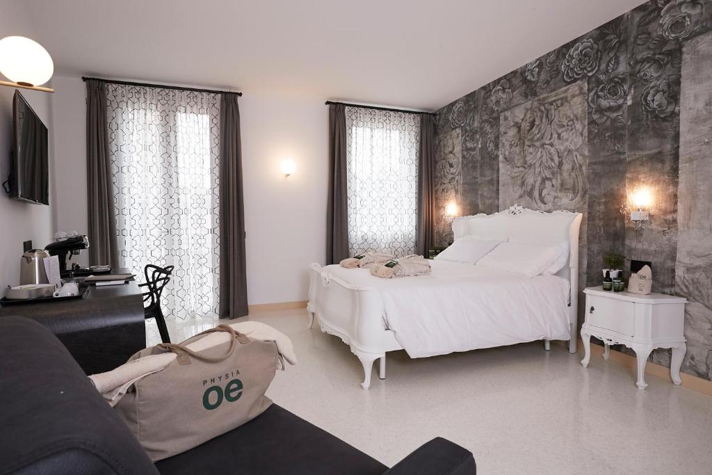 una camera con un grande letto bianco e un divano di Antica Pusterla Relais de Charme a Vicenza