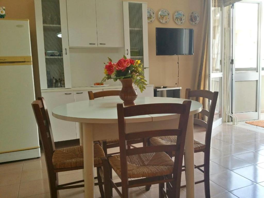 una cocina con una mesa con un jarrón de flores. en Residenza armonia, en Gallipoli