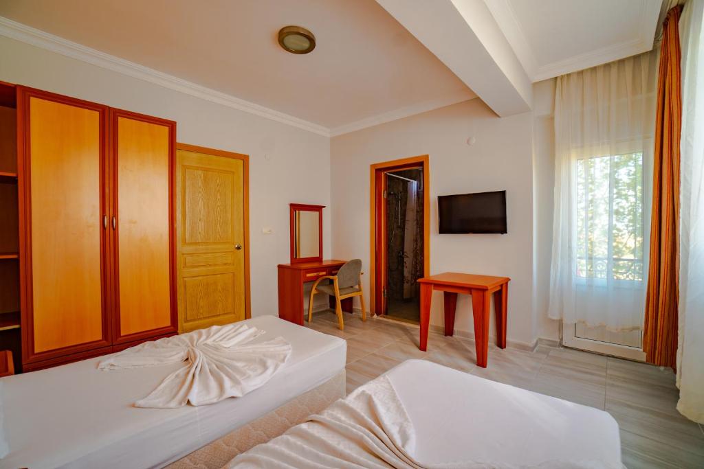 a bedroom with two beds and a desk and a television at Belek Akropolis Medusa Otel in Belek