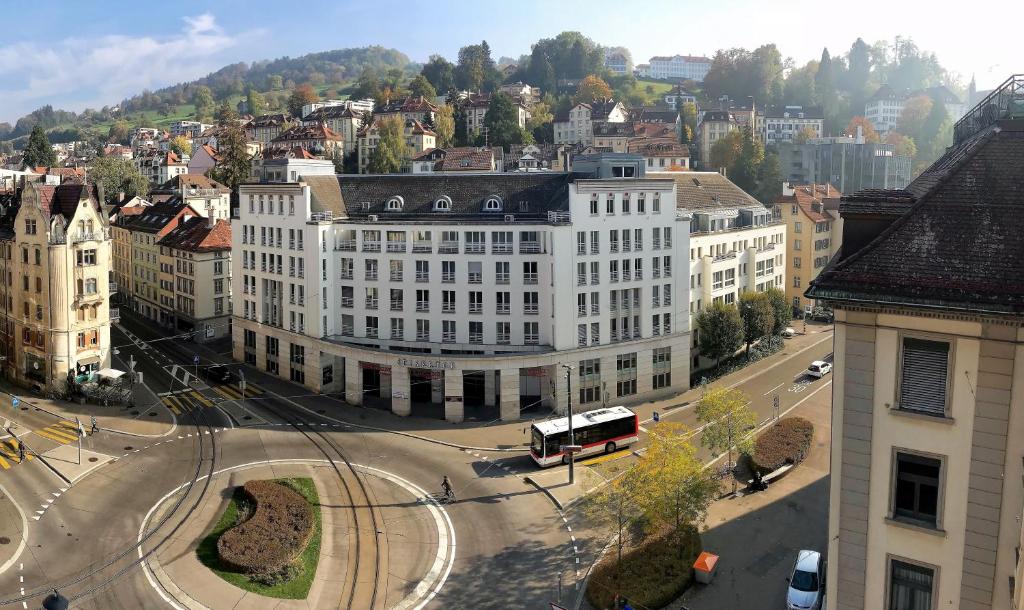 um grande edifício branco numa rua da cidade com um autocarro em Hotel am Spisertor em St. Gallen
