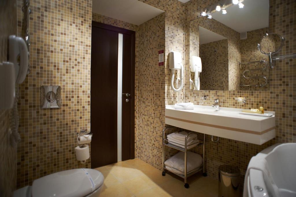 a bathroom with a sink and a toilet and a mirror at AZIMUT Hotel Siberia in Novosibirsk