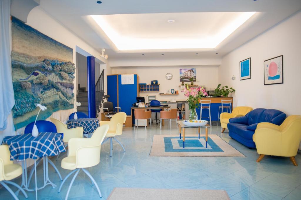 a living room with chairs and a blue couch at Riviera Residence in Marina di Pietrasanta