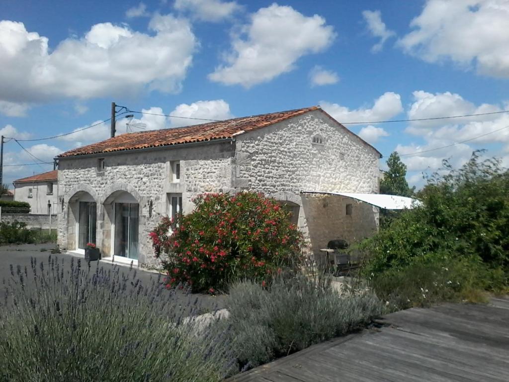 Casa de piedra blanca con techo rojo en Gîte climatisé *** Le Pigeonnier, en Pons