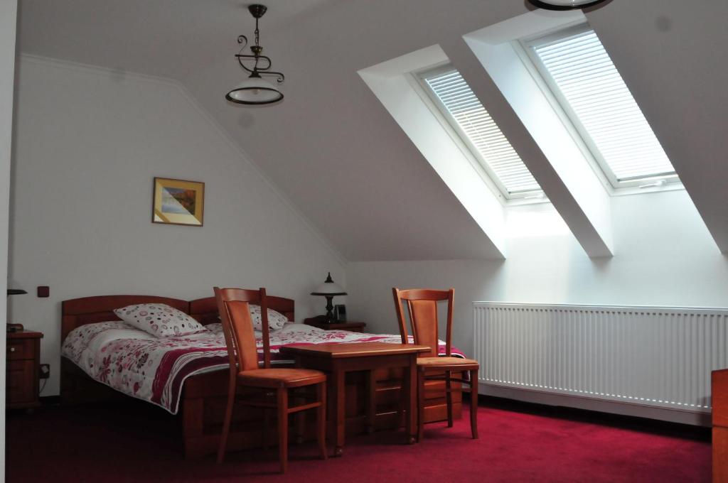 1 dormitorio con 1 cama, mesa y sillas en Hotel Pegas Brno en Brno