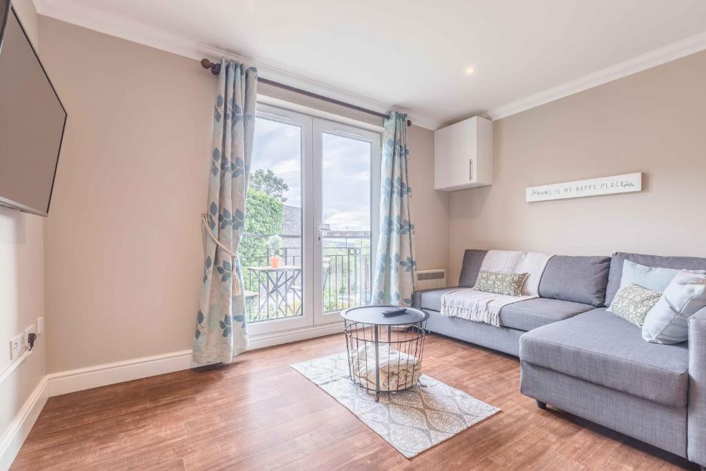 uma sala de estar com um sofá e uma janela em Modern apartment within short walk of The Castle, High Street and Long Walk - FREE PARKING em Windsor