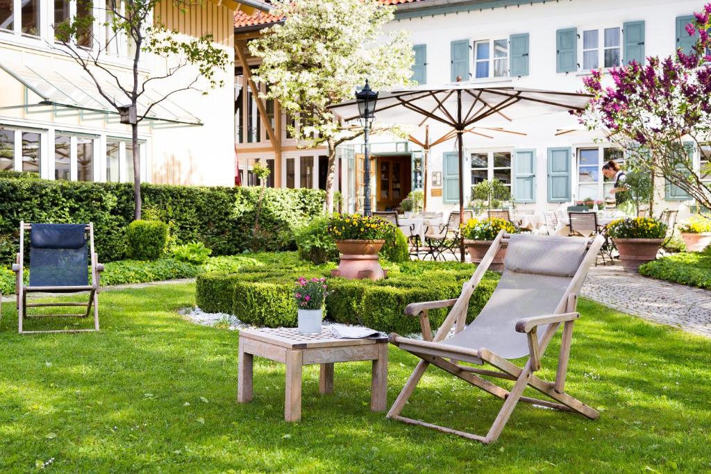 two chairs and a table in a yard at Seitner Hof in Pullach im Isartal