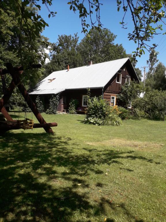 a brown barn with a white roof in a yard at Agrohaczow za rzeką in Haczów