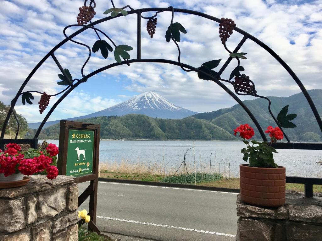 uma vista para uma montanha através de um arco de metal com flores em Private Hotel Rei em Fujikawaguchiko