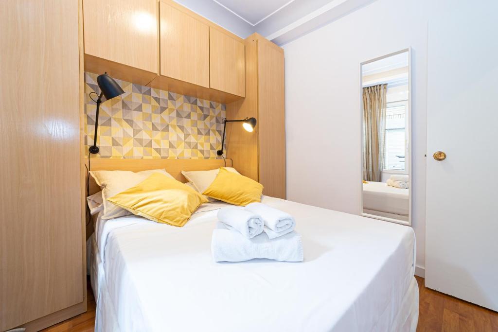 マドリードにあるApartamento Trafalgarのベッドルーム1室(大きな白いベッド1台、タオル付)
