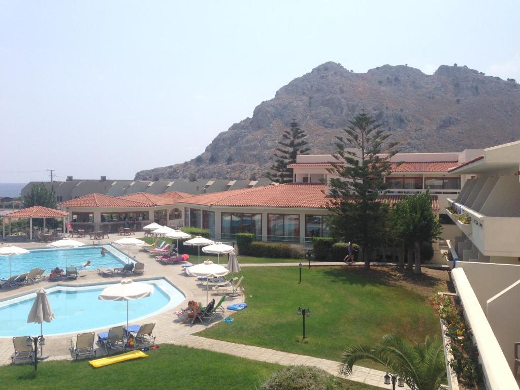 um resort com piscina e uma montanha ao fundo em KOLYMBIA SKY HOTEL em Kolimbia