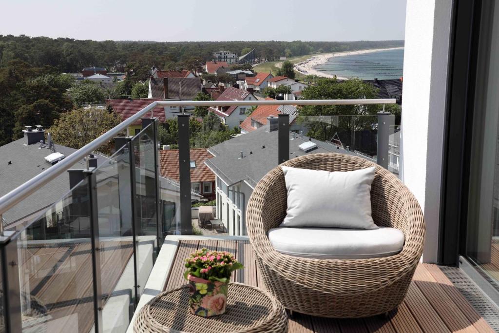 a rattan chair sitting on a balcony with a table at Penthousewohnung Kapkieker in Glowe