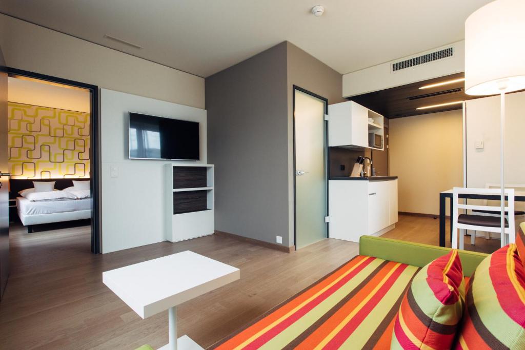 un soggiorno con un divano e un tavolo di harry's home Dornbirn hotel & apartments a Dornbirn