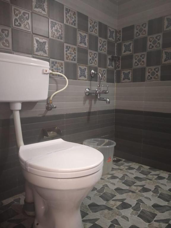 a bathroom with a white toilet in a room at Landy Queen in Munnar