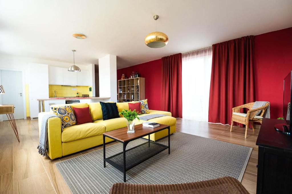 a living room with a yellow couch and a table at Chez Emile Private 5 star 3 room flat and in-door Pkg in Nitra