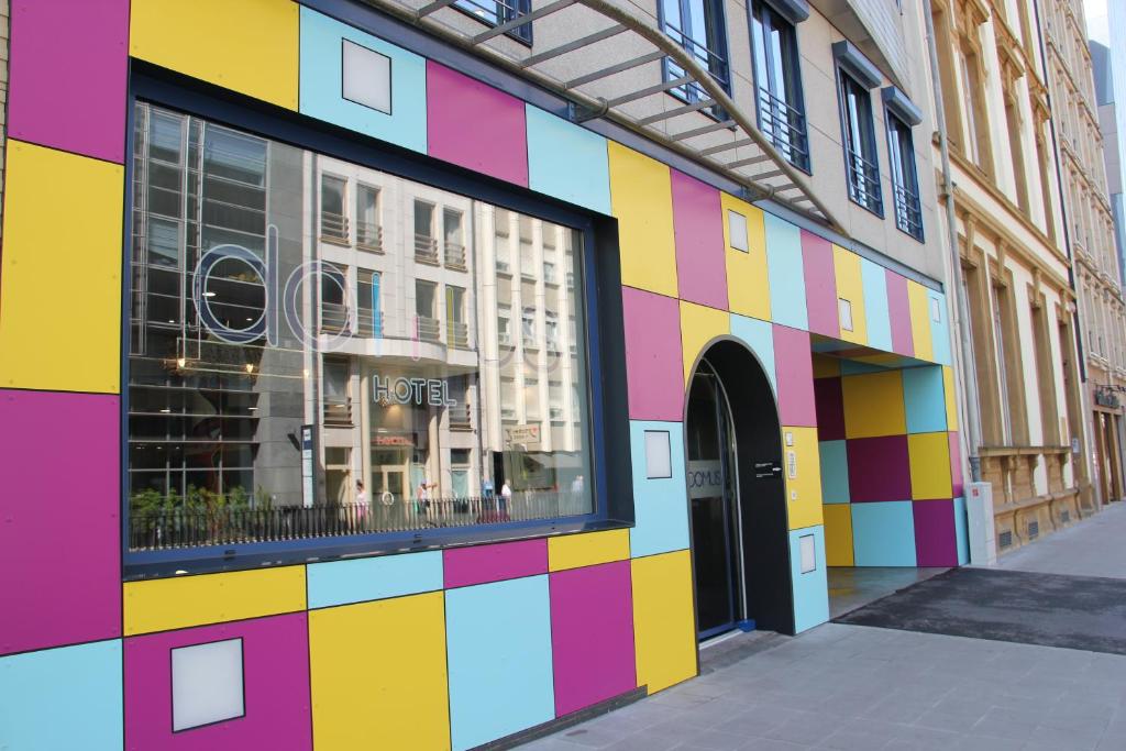a colorful building with a window on a street at Domus Hotel in Luxembourg