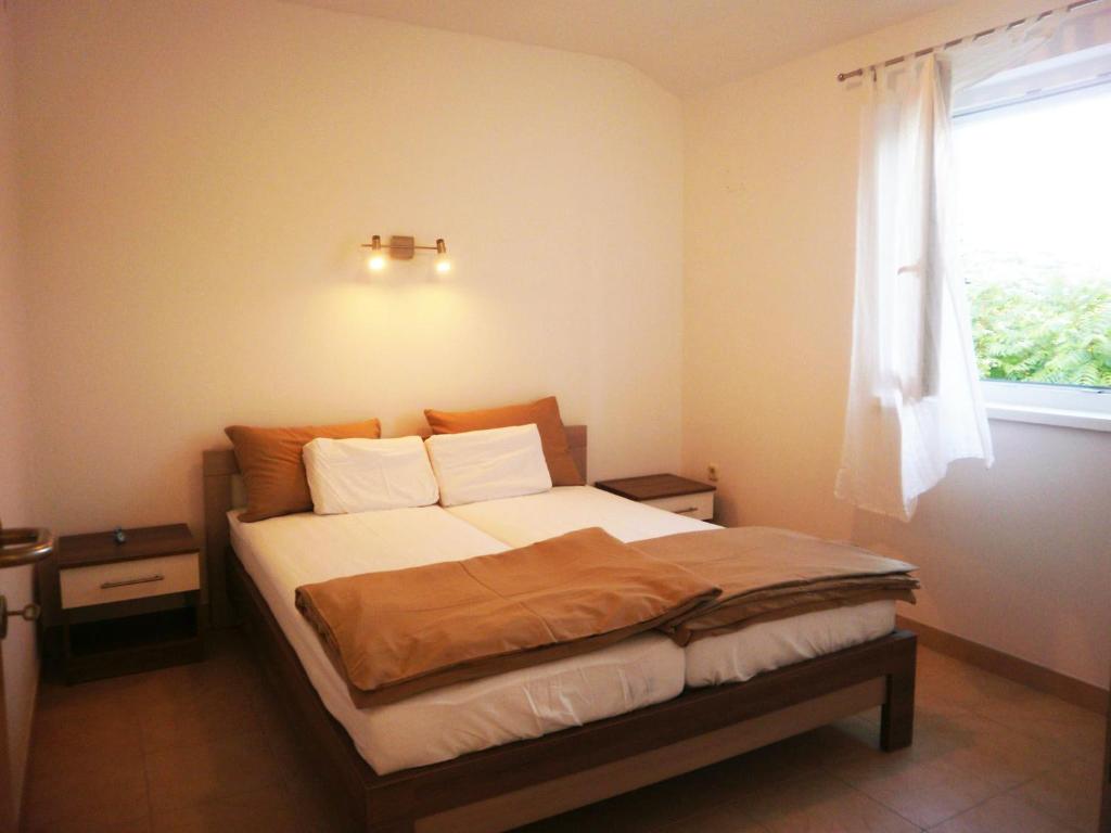 1 dormitorio con 1 cama grande y ventana en Apartments Lana and Lili, en Preko