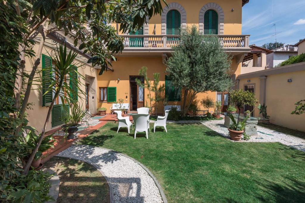 a garden with a table and chairs in front of a house at Villa Il Mosaico in Florence