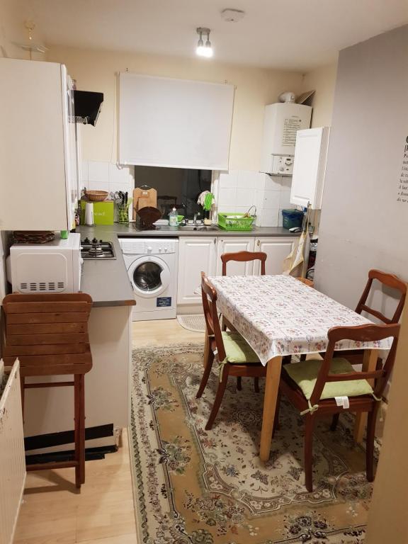 - une cuisine avec une table, une table et des chaises dans l'établissement Family Rest At Best Location with Best Price, à Londres
