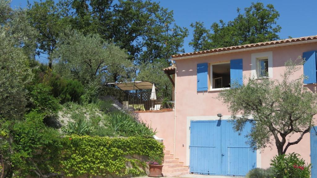 una casa con una puerta azul y árboles en Gite Mas du Cigalon en Mirabel-aux-Baronnies