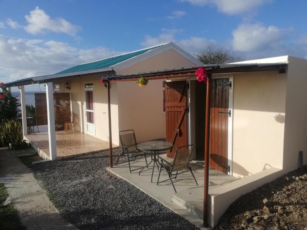 ein Haus mit einer Terrasse mit Stühlen und einem Tisch in der Unterkunft Chez Mimi in Rodrigues Island