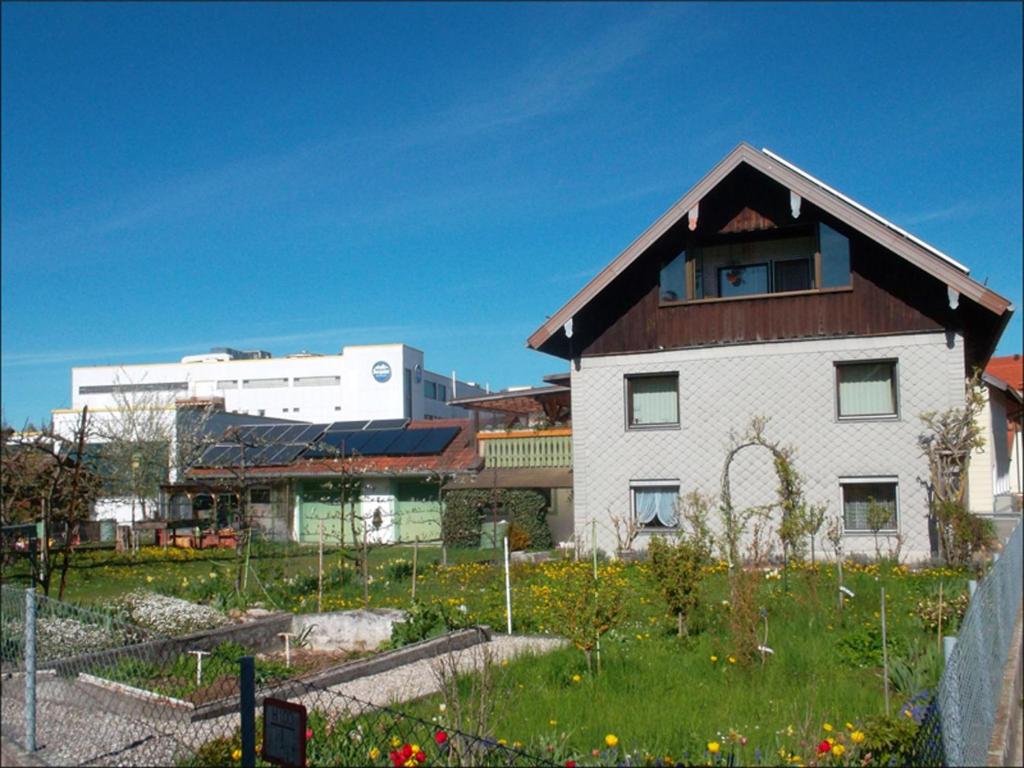 a white house with a brown roof in a field at Zeiler Peter und Luisie in Waging am See