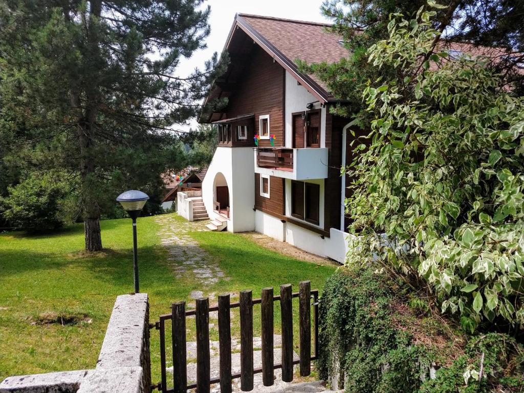 a house with a fence in front of it at Relax sull'Altopiano di Asiago in Gallio