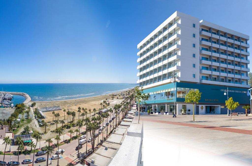 a building on the beach next to the ocean at Sun Hall Hotel in Larnaka