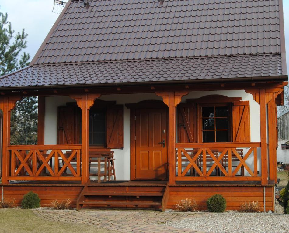 una casa con porche y techo en Domek w Bartoszymlesie, en Stara Kiszewa