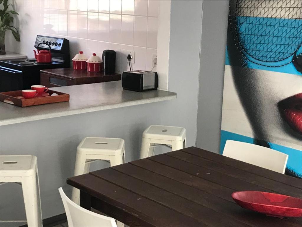 een eetkamer met een tafel en vier krukken bij Tortilla no 3 in Bloemfontein