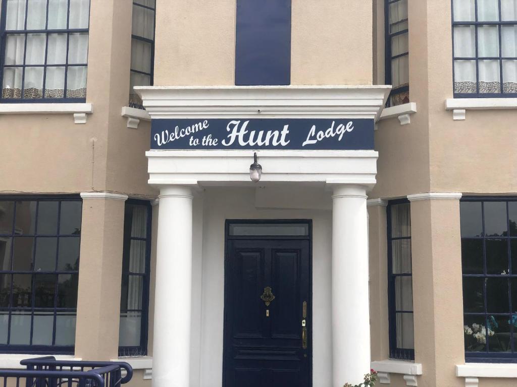 un edificio con una señal para el pabellón de caza en The Hunt Lodge en Leighton Buzzard