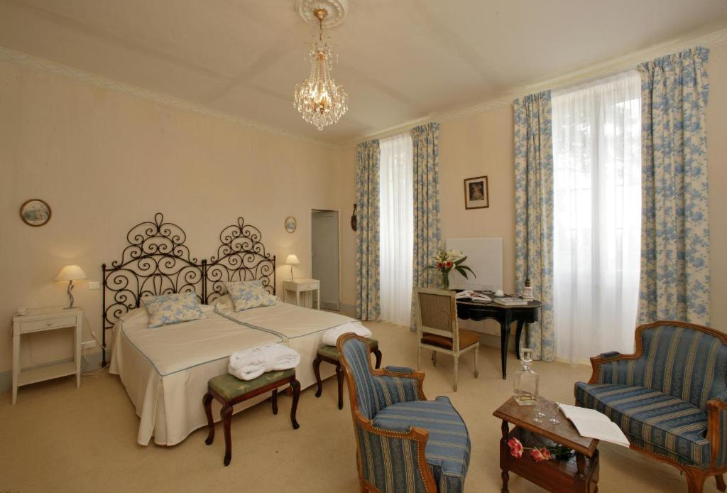 a bedroom with a bed and a table and chairs at Le Manoir Saint Jean in Saint-Paul-dʼEspis