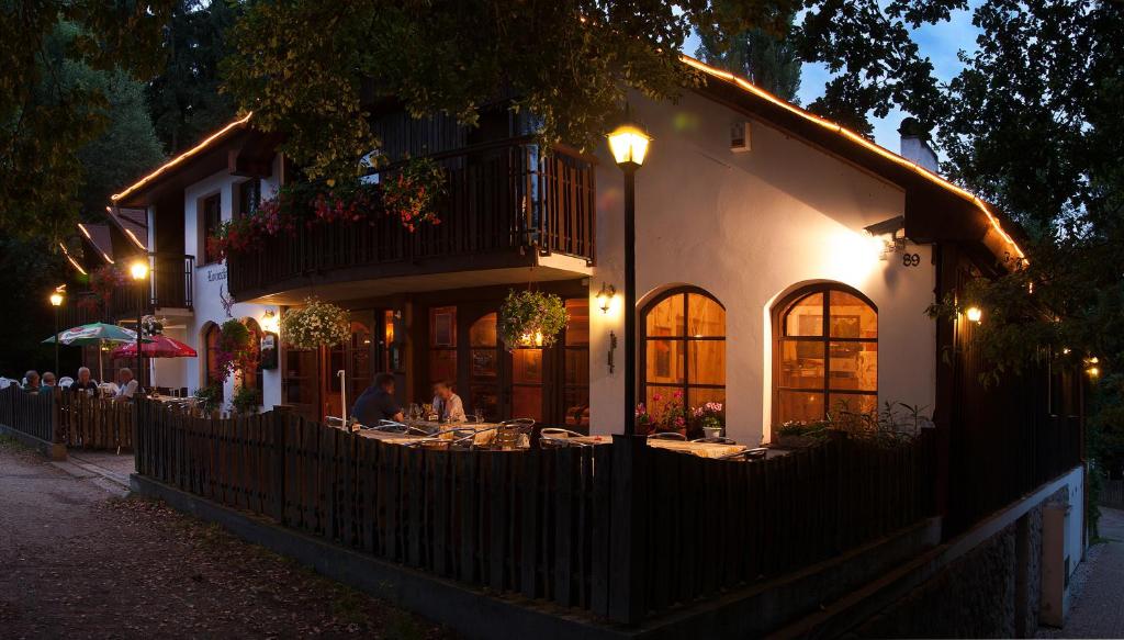 ein Restaurant mit Leuten, die vor einem Gebäude an Tischen sitzen in der Unterkunft Lovecký hotel Jívák in Loučeň