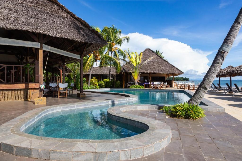 a swimming pool at a resort with a resort at Corail Noir Hotel in Ambaro