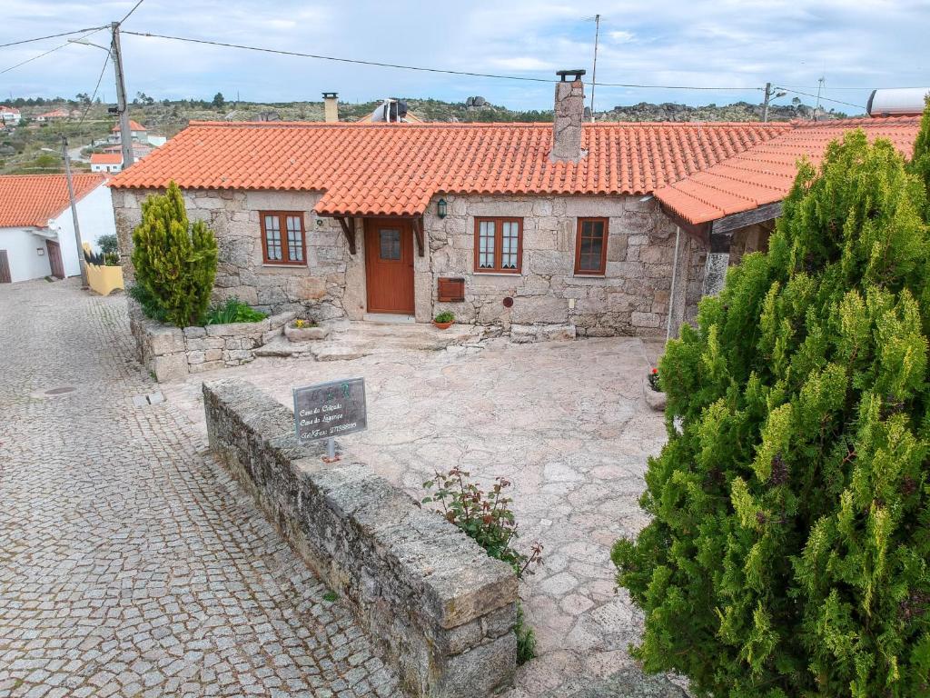 uma antiga casa de pedra com um telhado laranja em Casas da Lagariça em Sortelha