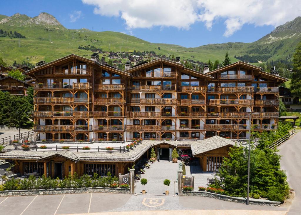 um hotel nas montanhas com montanhas ao fundo em La Cordée des Alpes SUP em Verbier