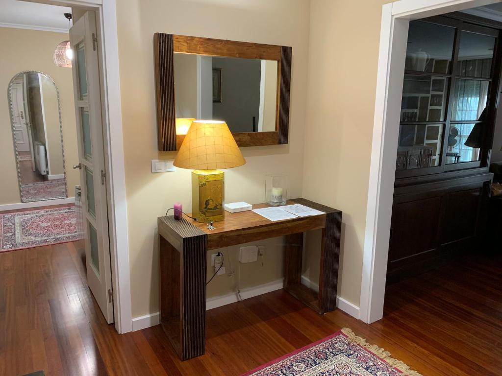 a lamp on a desk in a room with a mirror at Home Sweet Home in Caldas de Reis