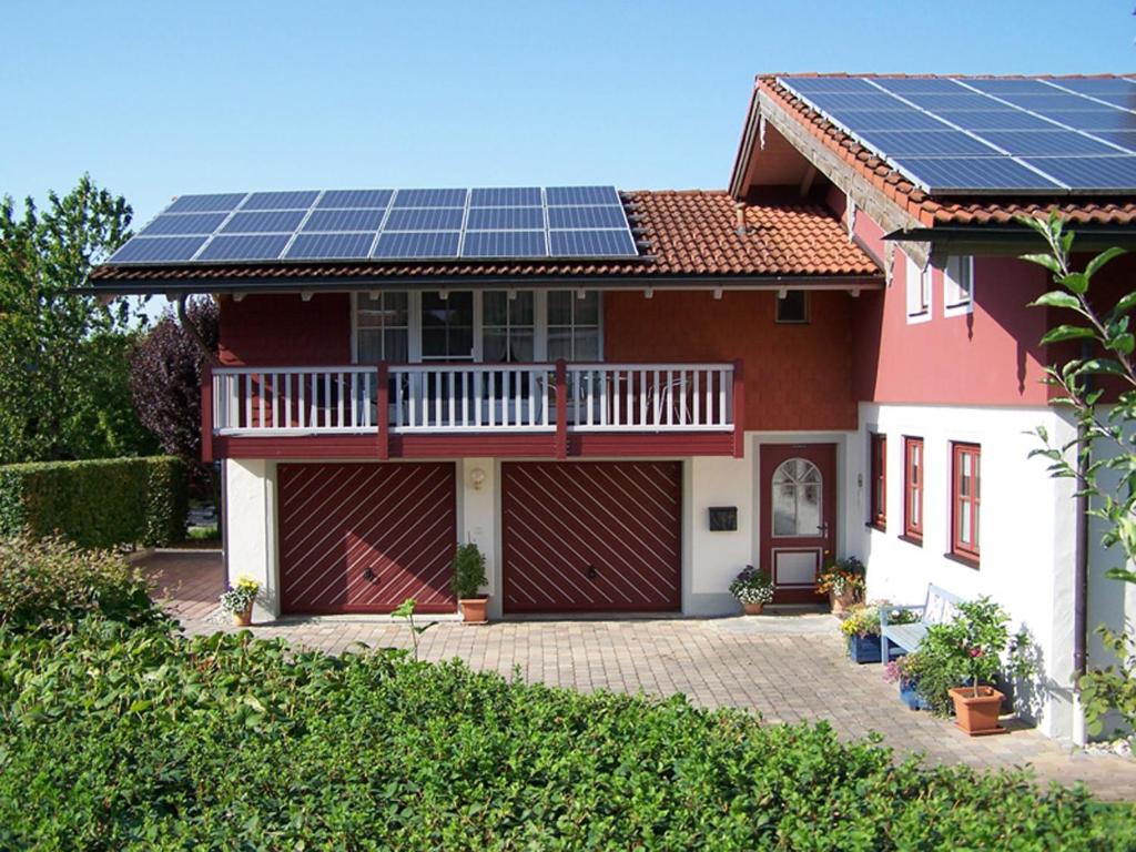 ein Haus mit Sonnenkollektoren auf dem Dach in der Unterkunft Ferienwohnung Sunkler in Waging am See