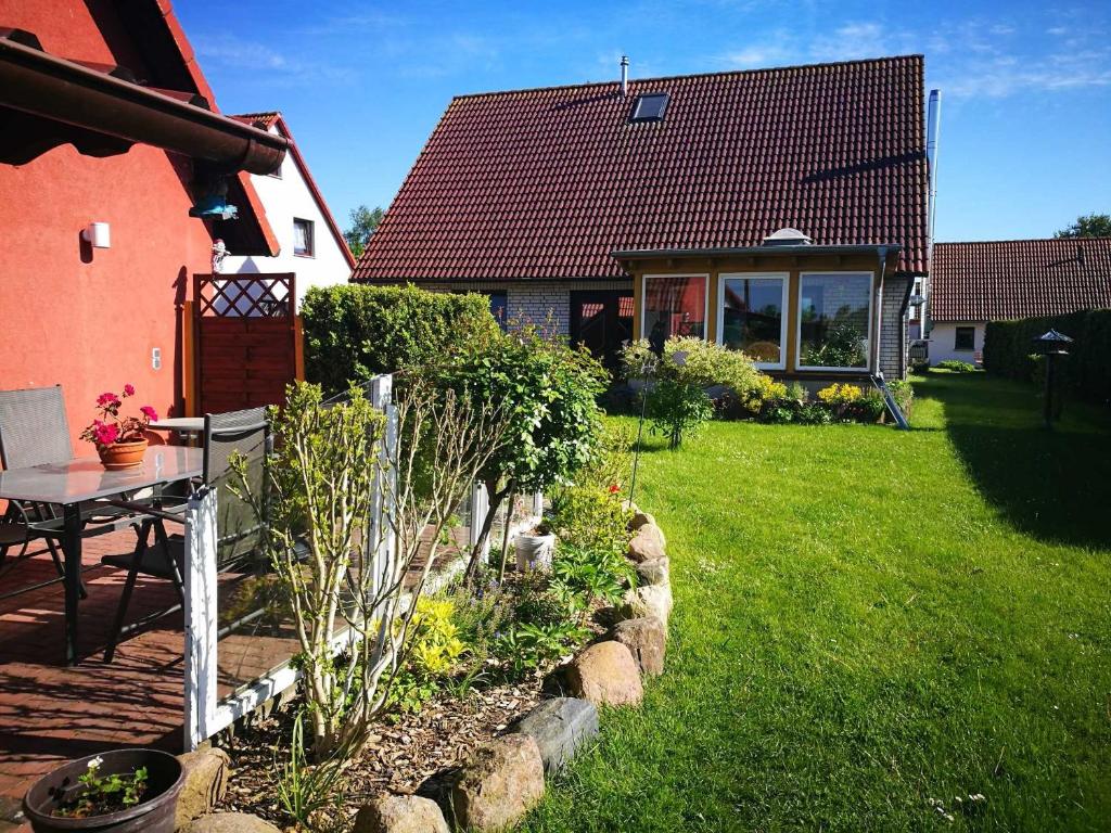 a garden in front of a house with a table at Ruegen_Fewo 28 a in Lobbe