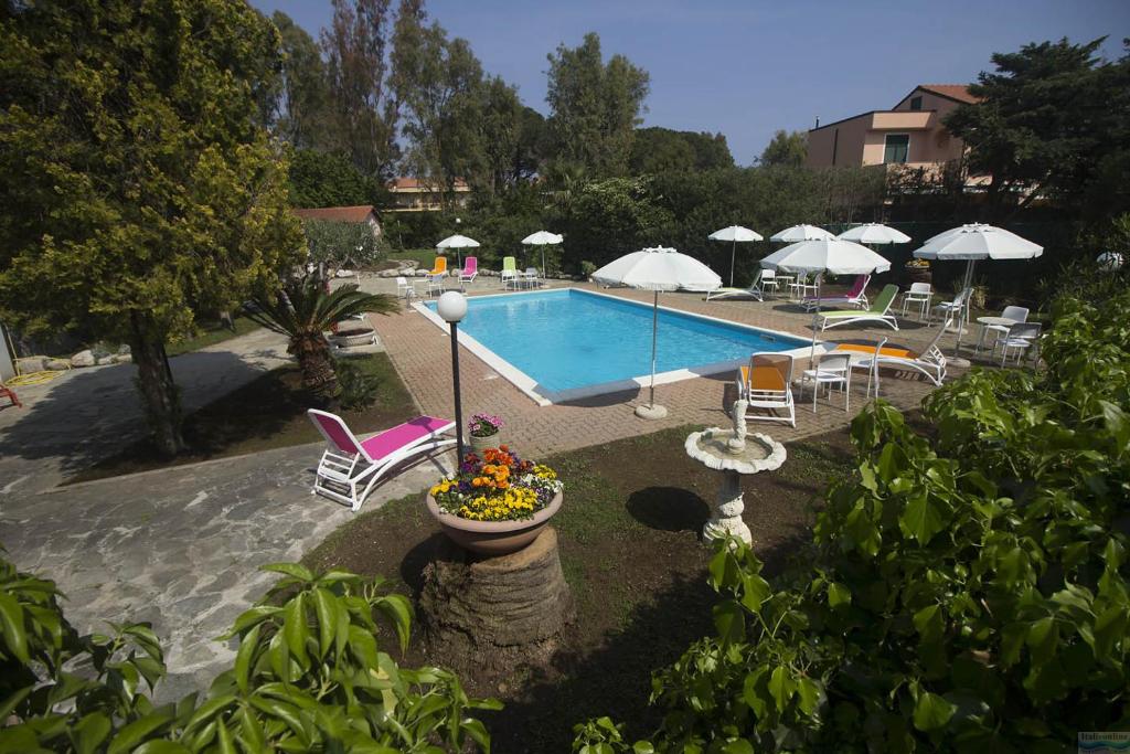 uma piscina com cadeiras e guarda-sóis em Loano Apartment Pool & Garden em Loano