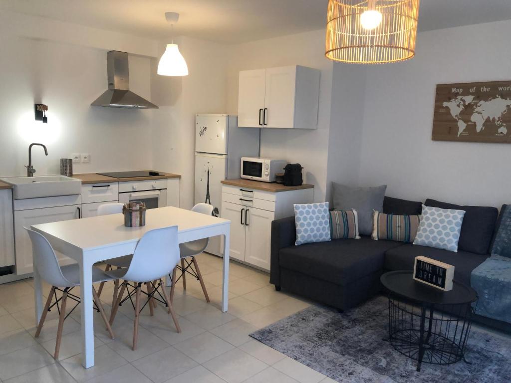 uma cozinha e sala de estar com uma mesa e um sofá em Coccon 1 By Dream Apartments em Serris