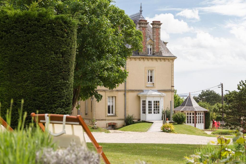 a large house with a tower on top of it at Les Villas d'Arromanches, Teritoria in Arromanches-les-Bains